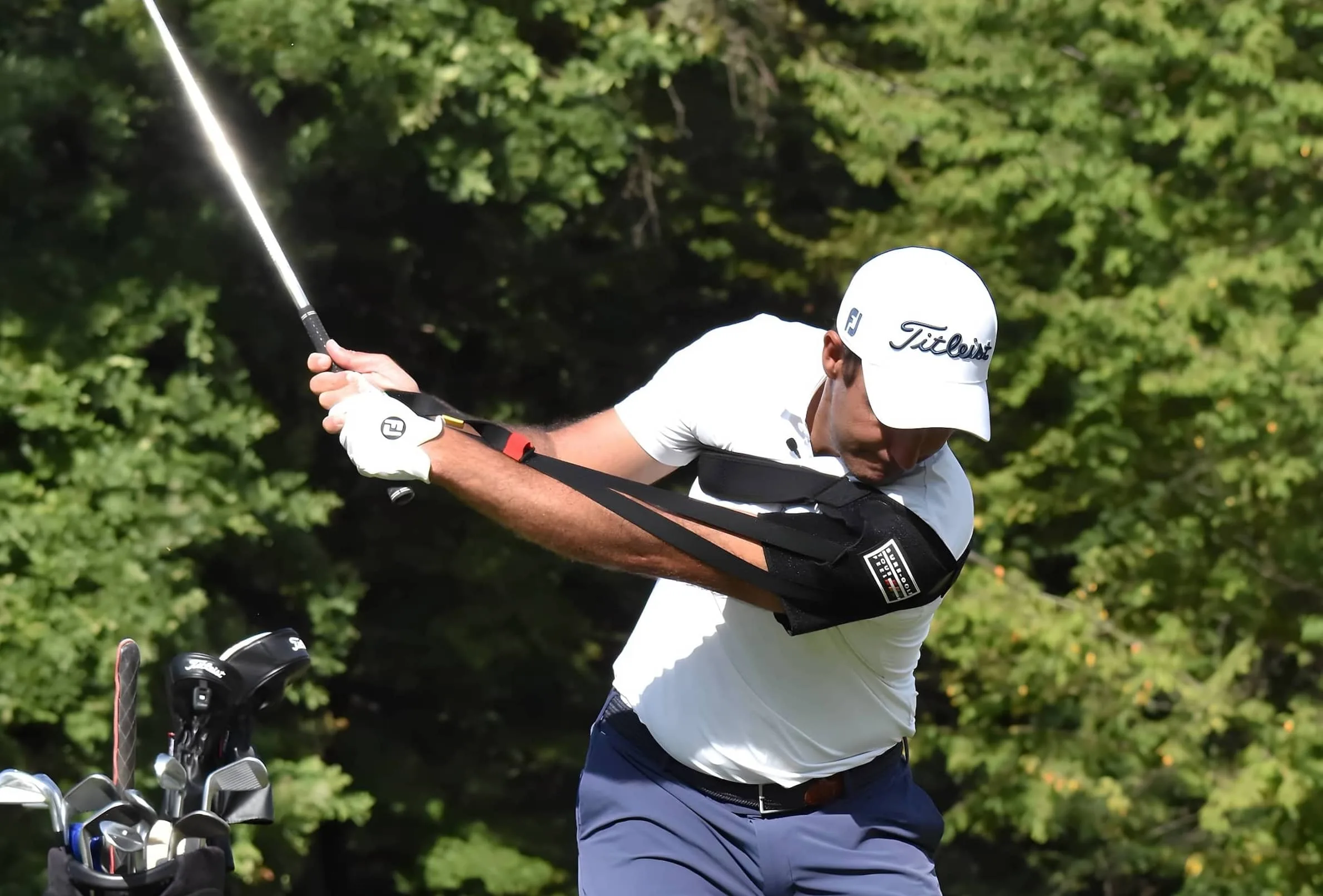 Golfer wearing training aid on arm