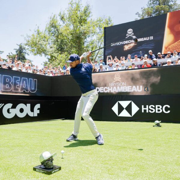 Bryson DeChambeau teeing off with HSBC board in background