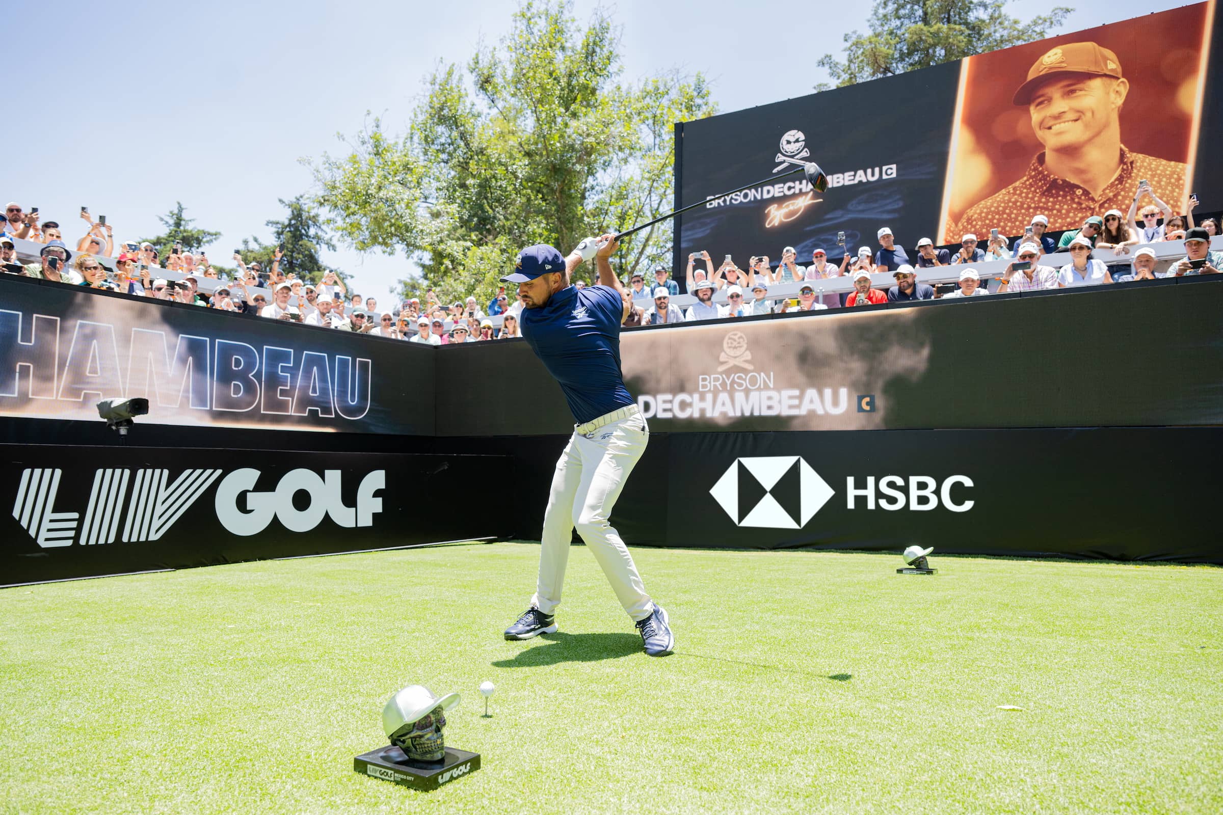 Bryson DeChambeau teeing off with HSBC board in background
