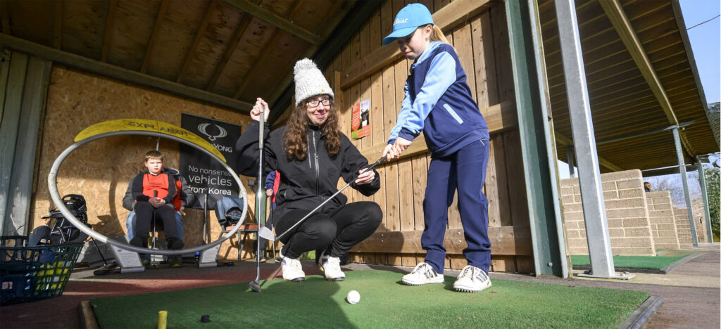 Junior Golfer under instruction on the range