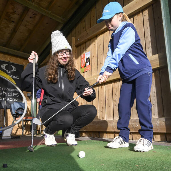 Junior Golfer under instruction on the range