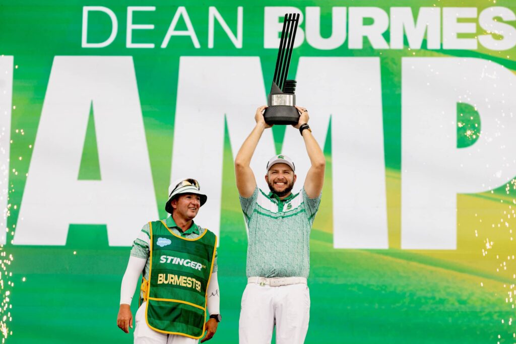 First place individual champion, Dean Burmester of Stinger GC and caddie, Jason Reynolds celebrate onstage with the trophy following the final round of LIV Golf Chicago at Bolingbrook Golf Club