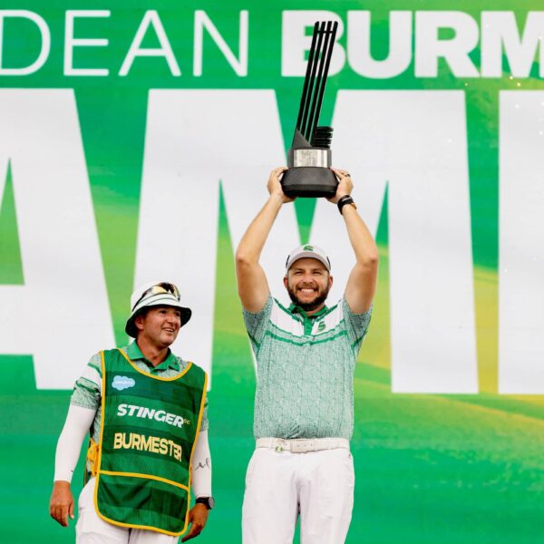 First place individual champion, Dean Burmester of Stinger GC and caddie, Jason Reynolds celebrate onstage with the trophy following the final round of LIV Golf Chicago at Bolingbrook Golf Club