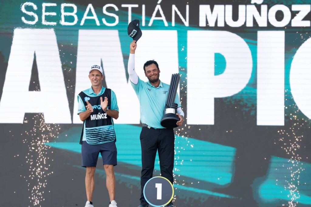First place individual champion, Sebastián Muñoz of Torque GC and caddie, Jose Campra celebrate on the podium following the final round of LIV Golf Indianapolis
