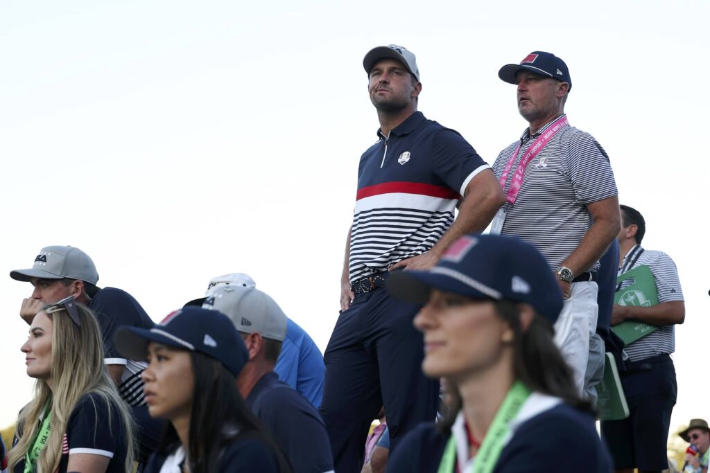 Bryson DeChambeau of Team United States and the Team United States spouses and partners watch the action on the 18th hole green during the 2025 Ryder Cup on the Black Course.
