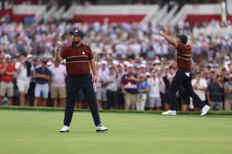 Shane Lowry of Team Europe celebrates after making his putt on the 17th hole alongside Rory McIlroy of Team Europe during the 2025 Ryder Cup on the Black Course
