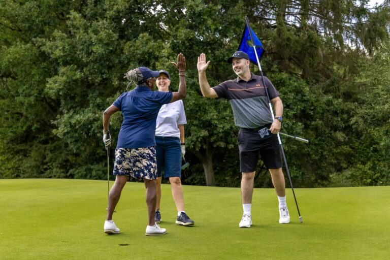 Amateur Golfers high five on the green