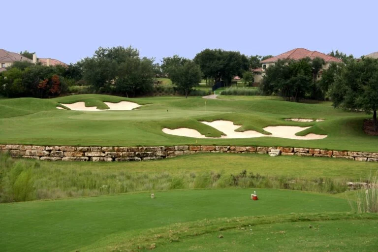 A view of the green on a scenic hill country golf course