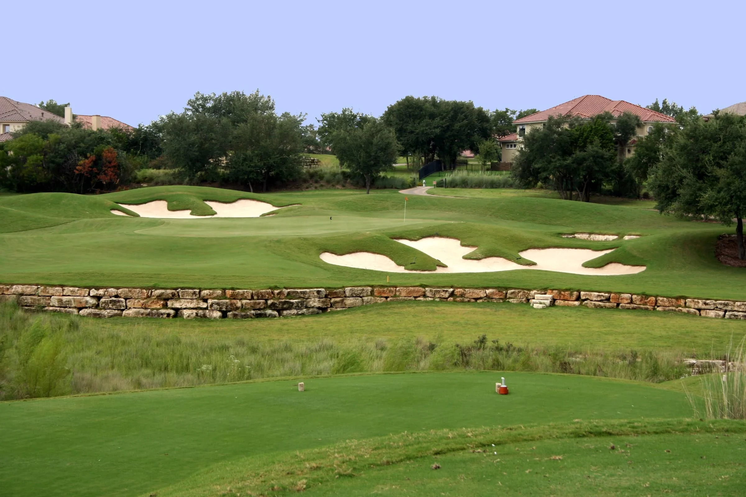 A view of the green on a scenic hill country golf course