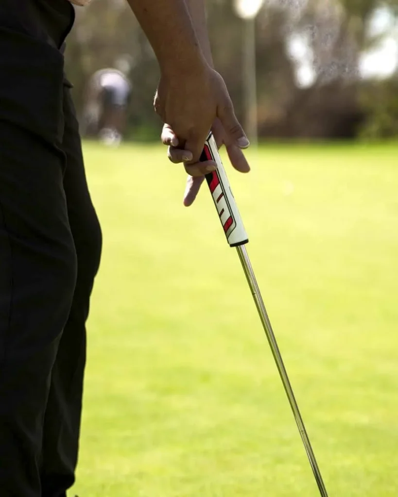 golfer with putter in hand on green